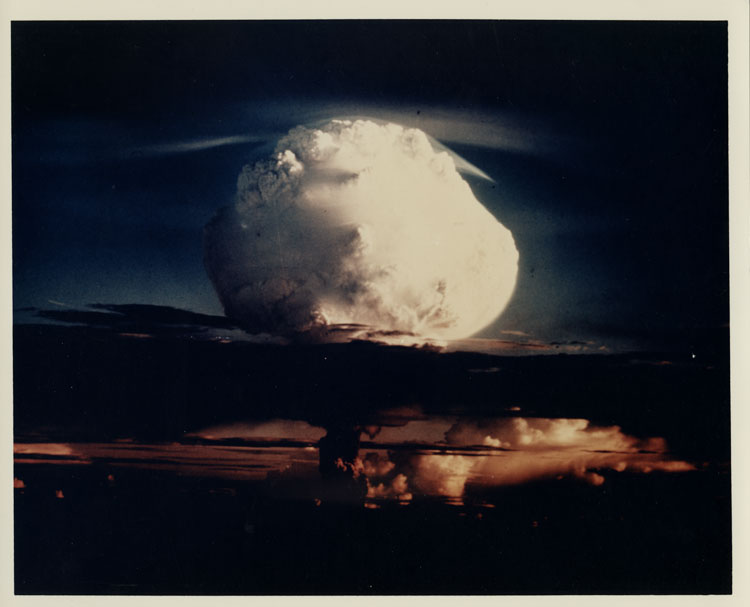 Color photograph of the mushroom cloud of Shot Mike, Operation Ivy, first thermonuclear device test based on Teller-Ulam staged radiation implosion, surface burst, Elugelab Island, Enewetak Atoll, 1 November 1952. Yield 10.4 megatons. No catalog number — verso blank.