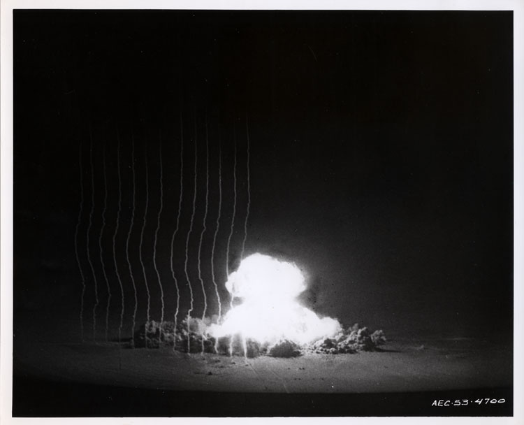 Fireball of Shot Annie, first nuclear detonation of Operation Upshot-Knothole, 91-metre tower, Yucca Flat, Nevada Proving Ground, 17 March 1953. Rocket smoke trails for blast wave measurement visible. Experimental device XR3, Mk-5 HE assembly, 16 kt. Lookout Mountain Laboratory, USAF. AEC-53-4700.