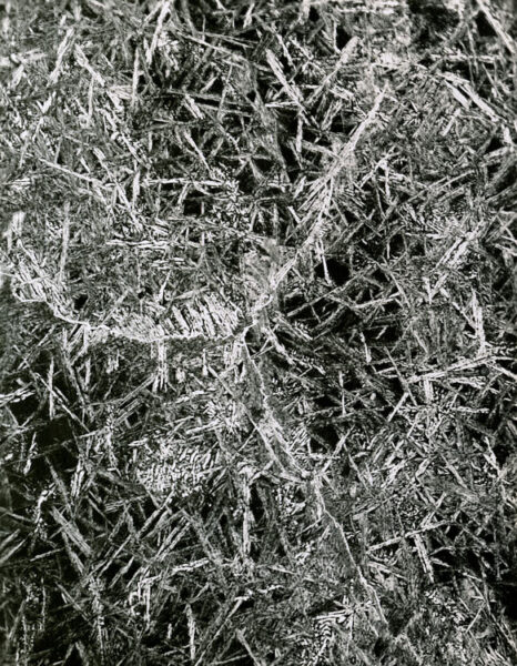 Photomicrograph of a uranium-2% molybdenum alloy thin section (30ppm carbon, Heat 19, sample B) at 500x magnification, showing crystalline grain structure. Eldorado Nuclear Limited Metallographic Laboratory, 1968.